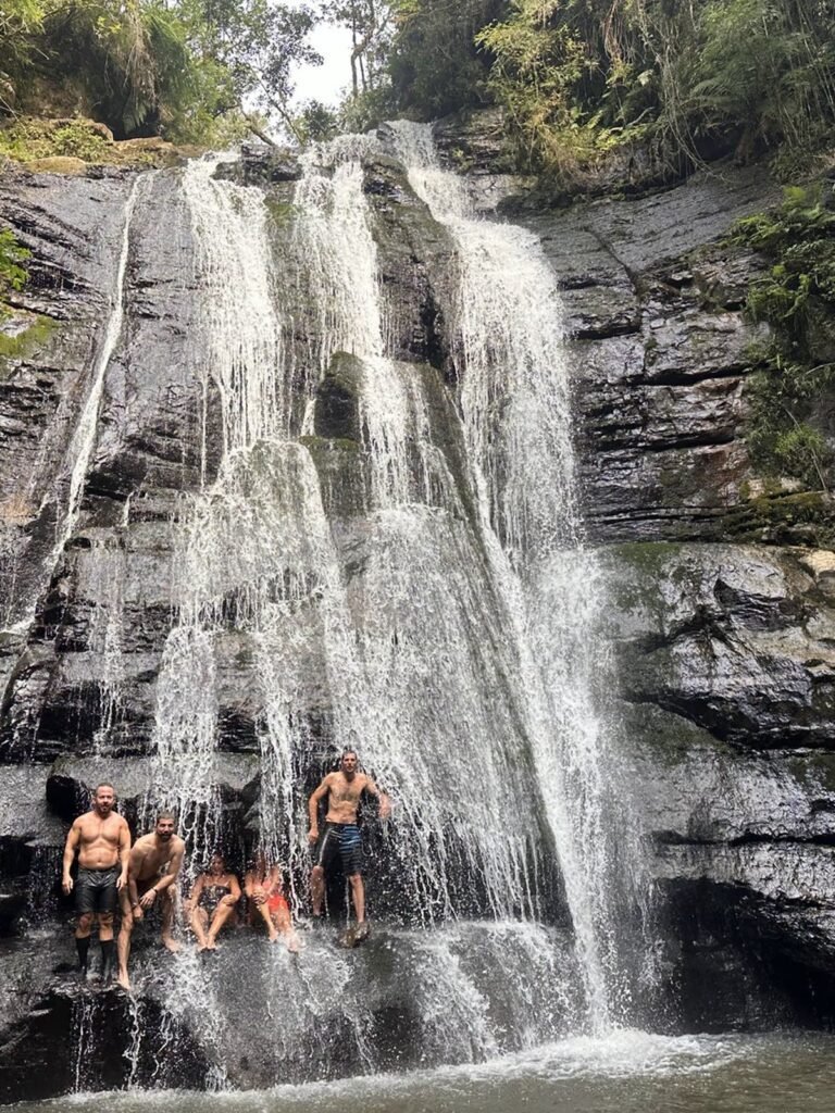 Uma das quedas do Sitio Sete Quedas, com pessoas embaixo da agua