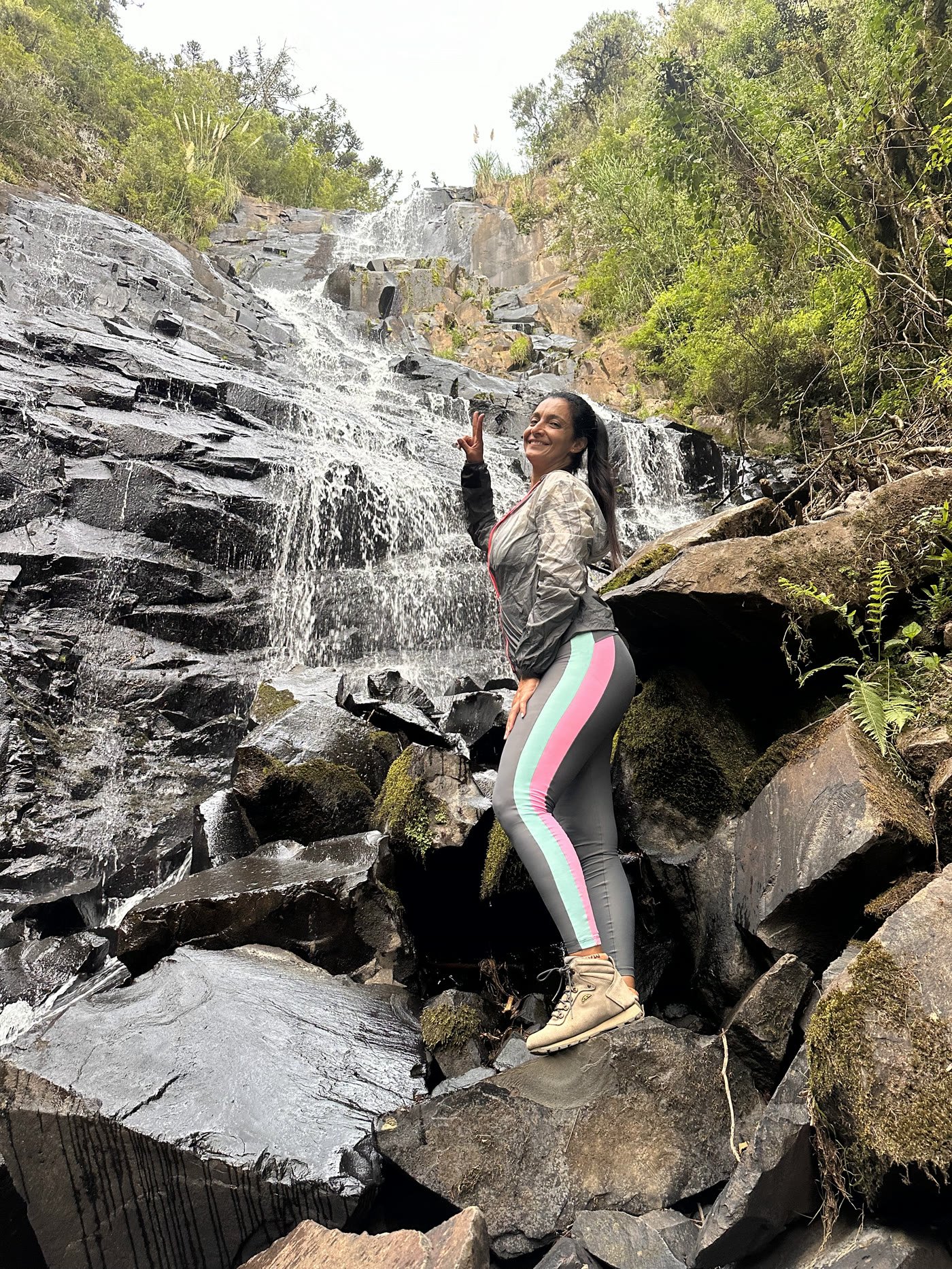 A Cascata Mundo Novo escorrendo por lajes escuras de pedra, em degraus