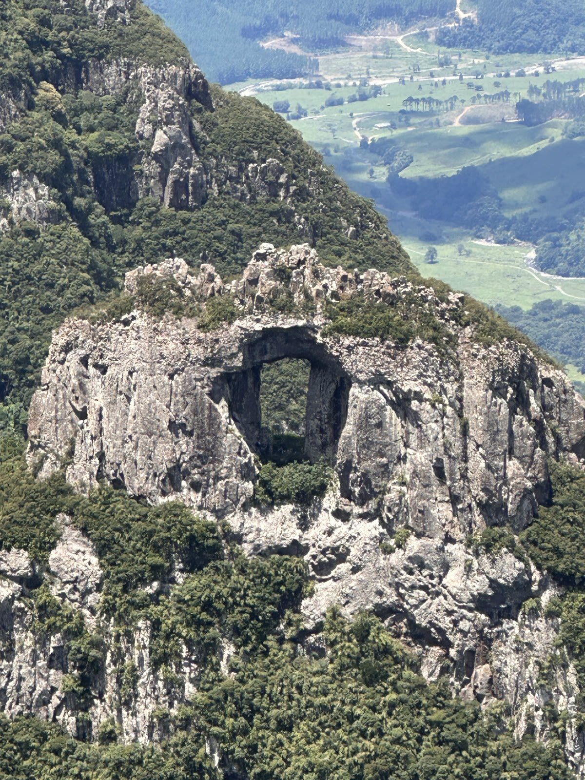 A Pedra Furada de Urubici vista do mirante do Morro da Igreja, com o vale verde ao fundo