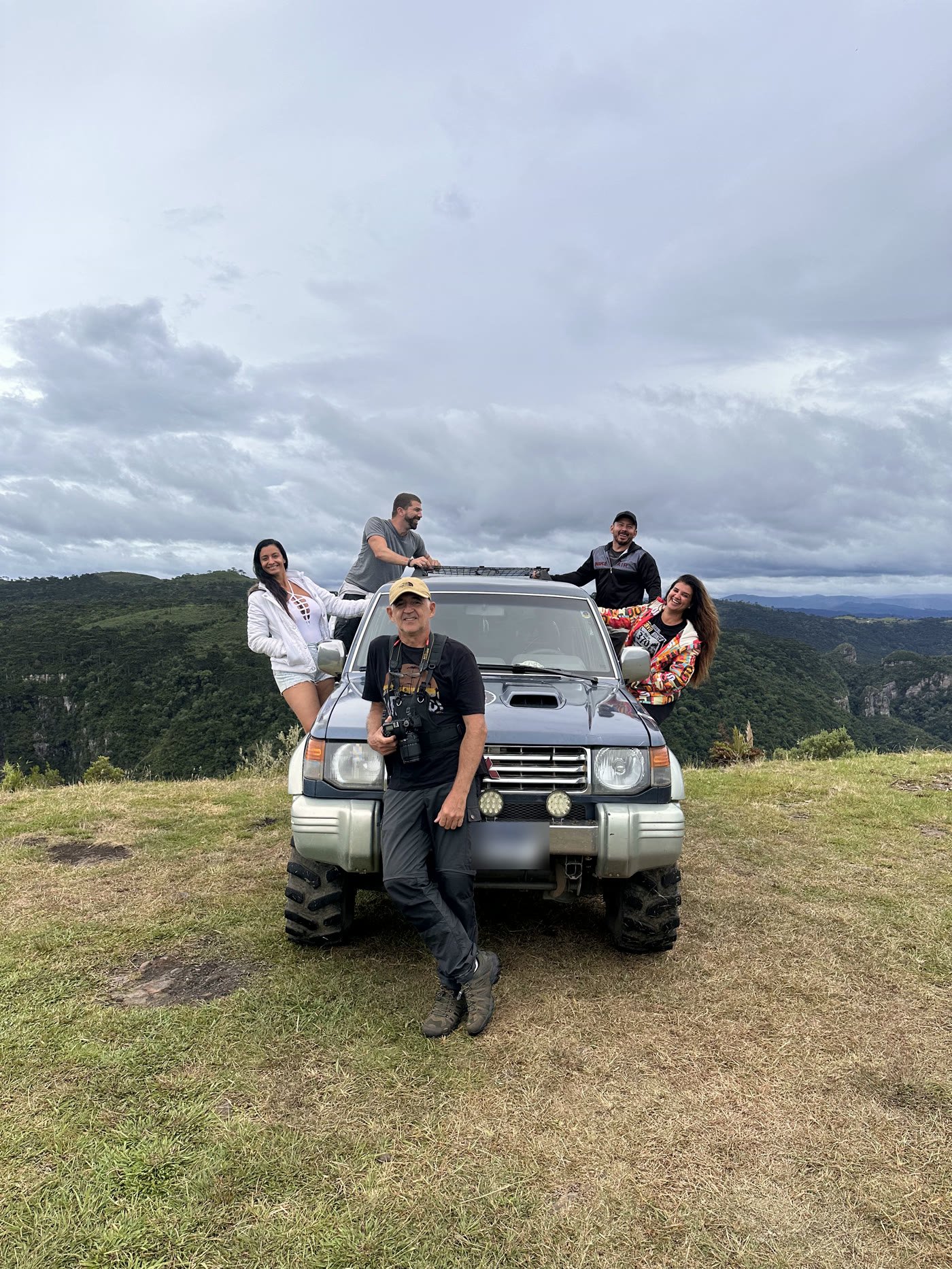 Grupo em volta de um jipe 4x4 no alto do Campo dos Padres, com o vale ao fundo